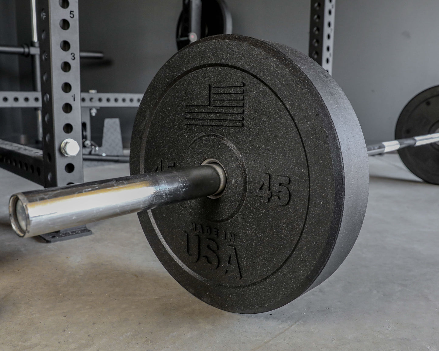 USA Bumper Plate Set - close up view with plate on a barbell on the ground (45 lbs)