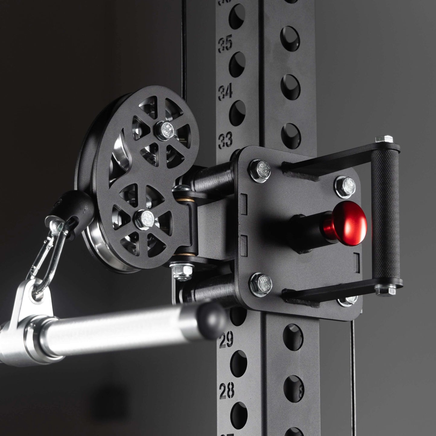 Close-up of heavy-duty steel pulley and adjustable handle for lat pulldown on a commercial functional trainer.