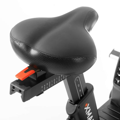 Close-up of a black adjustable bike seat with height markings for optimal comfort on the CAT 5 Hurricane air bike.